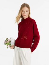 a lady in red mock neck sequins sweater with white pants